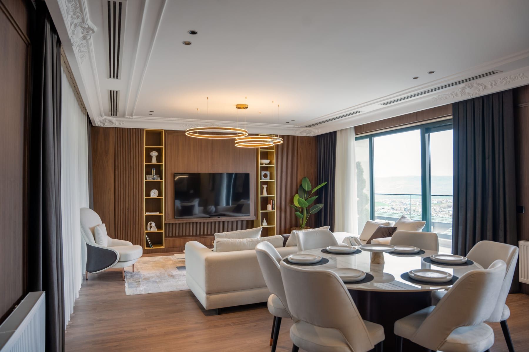 Open plan living and dining room zoned through lighting and a layered material mix