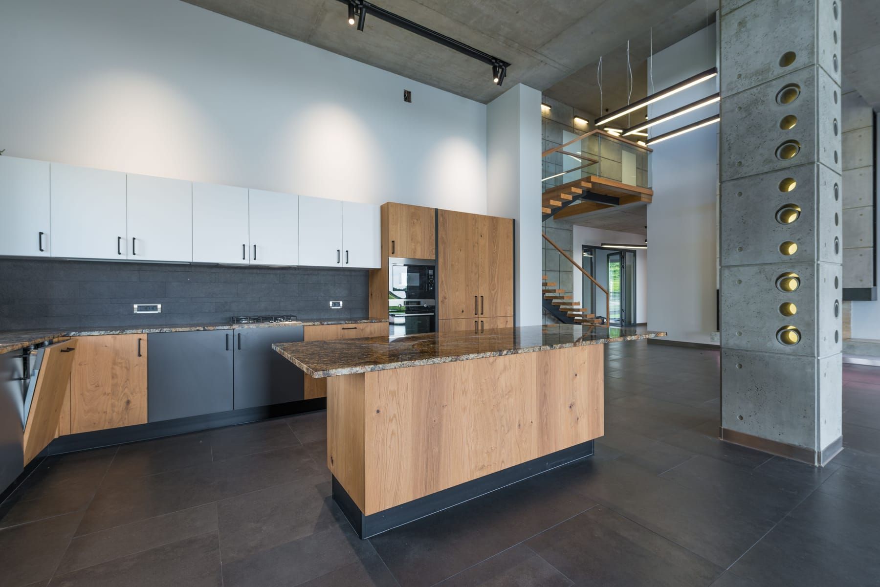 Sleek kitchen island with bar stools, handle-less cabinets and pendant lighting